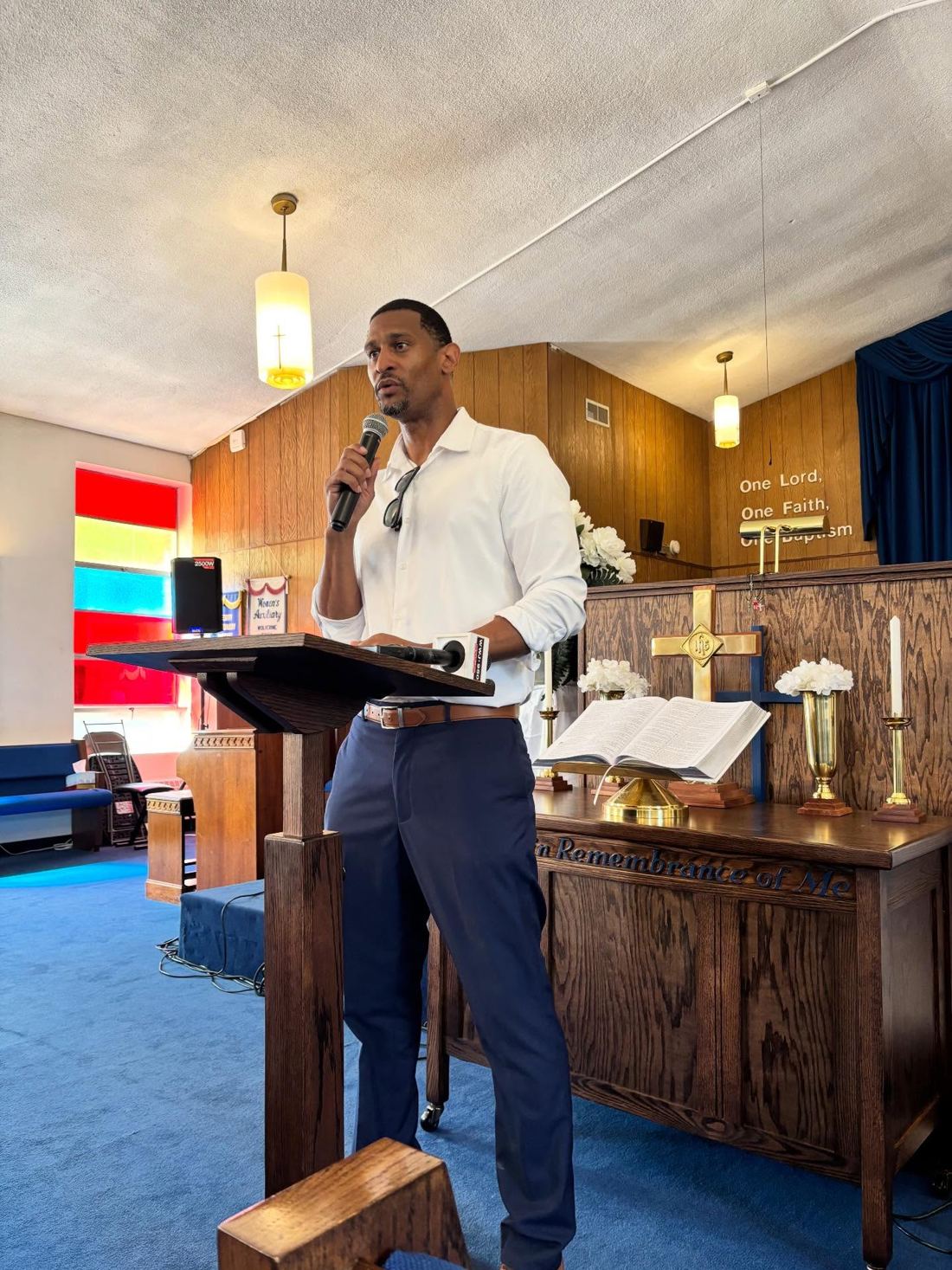 Marcus Bowman speaking at a podium inside a Pontiac church